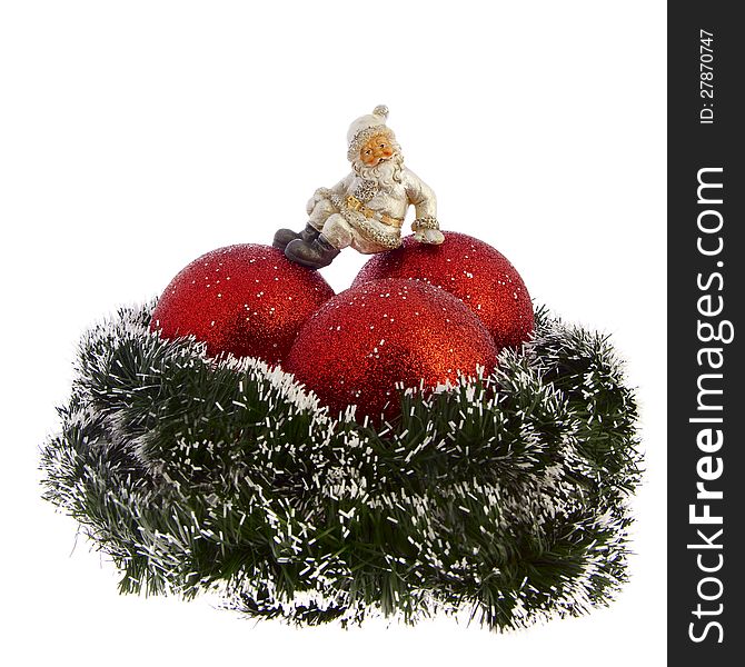 Christmas decoration isolated on white background. Three red balls into clumps. Top is figurine of Santa Claus. Santa Claus sitting on one of the balls.