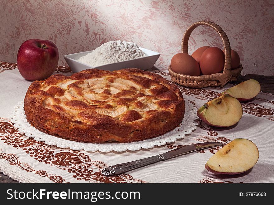 Homemade apple pie surrounded by fresh apples