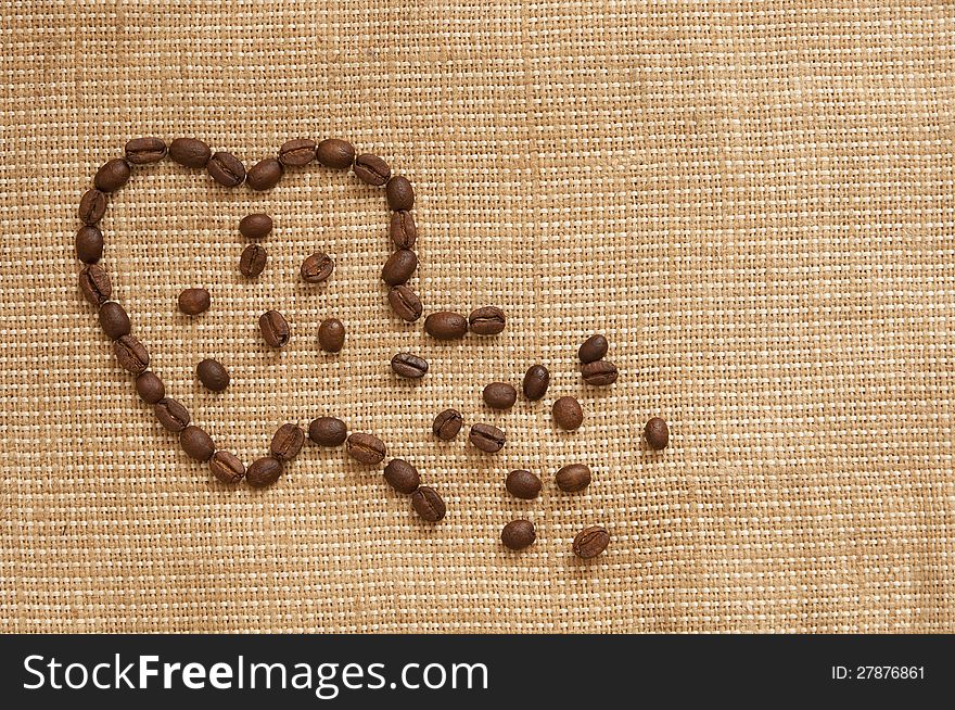 Love symbol made of coffee beans with ruptured contour