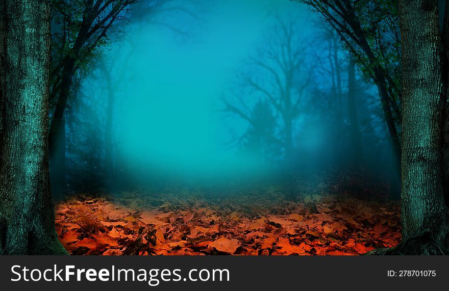 Autumn landscape. Fall in the woods. Red fallen leaves, leafless trees and branches silhouettes on blue misty blurry background