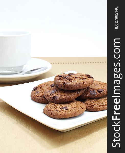 Chocolate cookie and cup of tea on white background