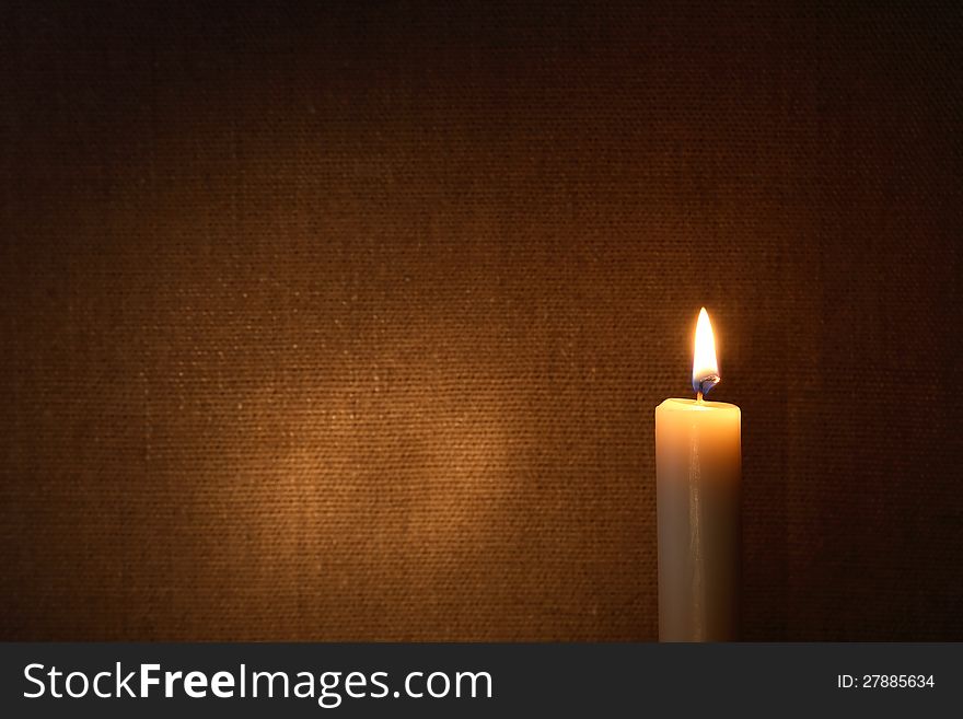 Lighting candle against canvas background with free space for text