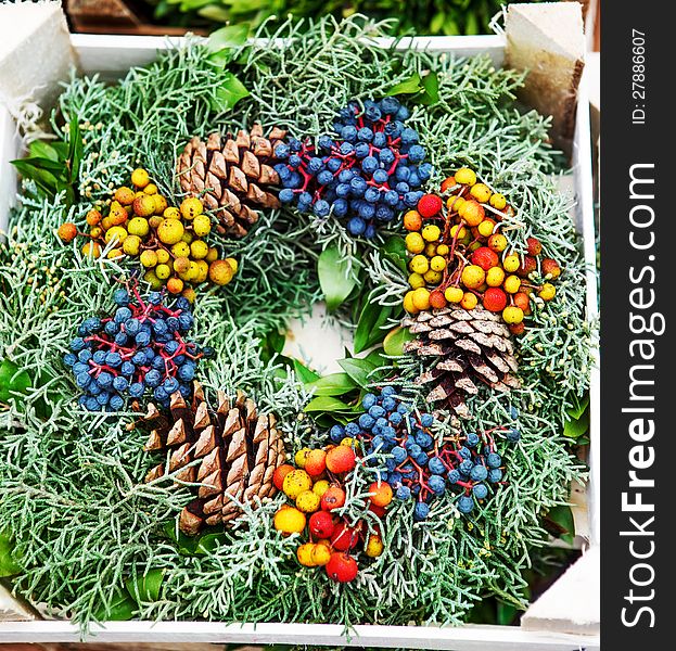 Evergreen wreath decorated with berries and cones