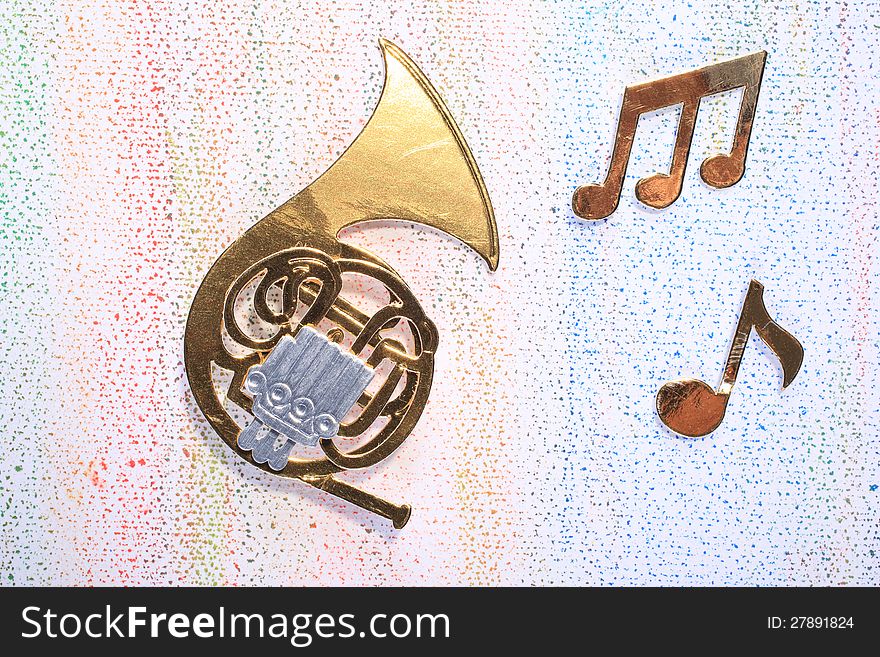 A symbolic French Horn made out of carton with musical notes on a light background. A symbolic French Horn made out of carton with musical notes on a light background