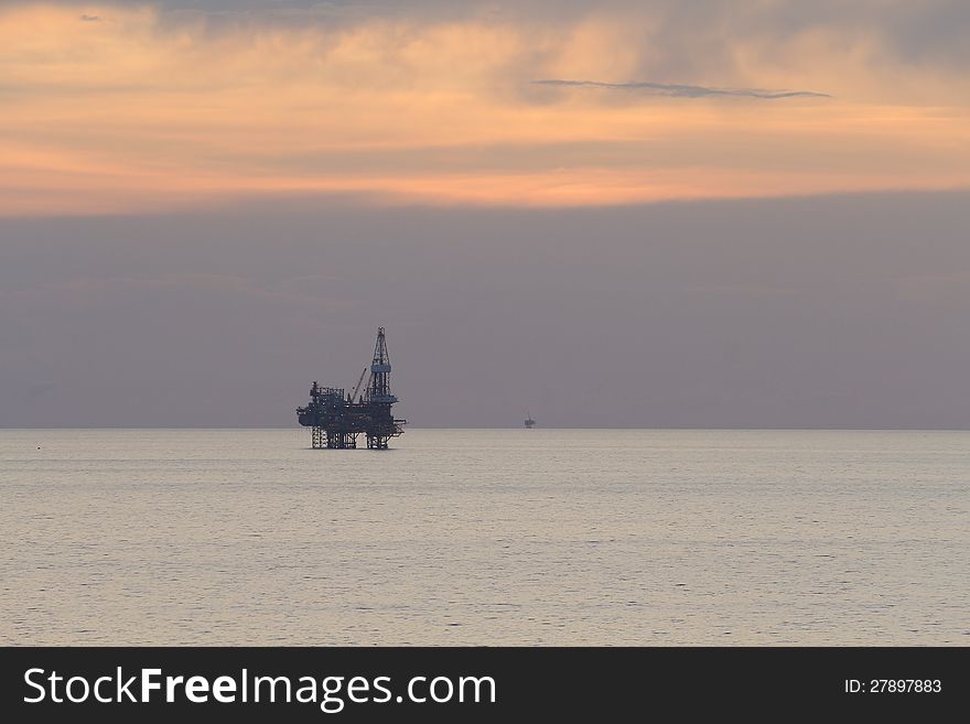 Jack up rig in the middle of the sea at sun set time