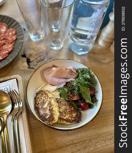 Cutlets, vegetables and sausage in a round light plate