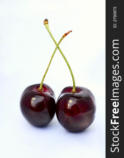 Two deep red cherries on white background. Two deep red cherries on white background