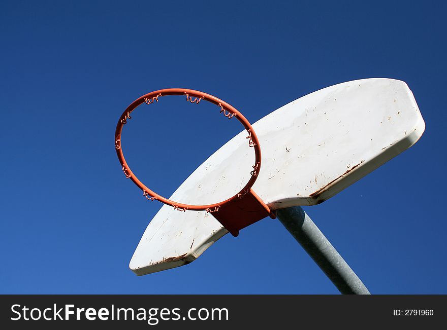 A playground basketball hoop against a blue sky. A playground basketball hoop against a blue sky.