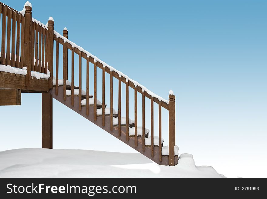 A snow covered deck and stairway. A snow covered deck and stairway
