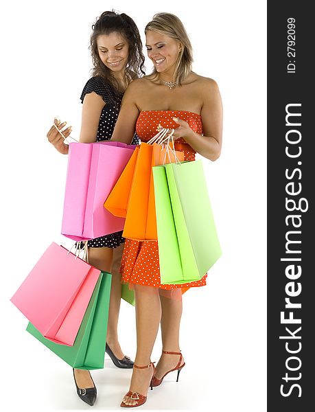 Two beautiful, young woman standing and holding bags. First woman is showing something in her's bag. Both woman are looking at bag. Isolated on white in studio. Whole body. Two beautiful, young woman standing and holding bags. First woman is showing something in her's bag. Both woman are looking at bag. Isolated on white in studio. Whole body