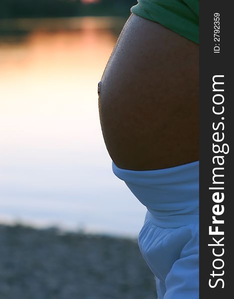 Silhouette of a pregnant woman on a lake at sunset. Silhouette of a pregnant woman on a lake at sunset