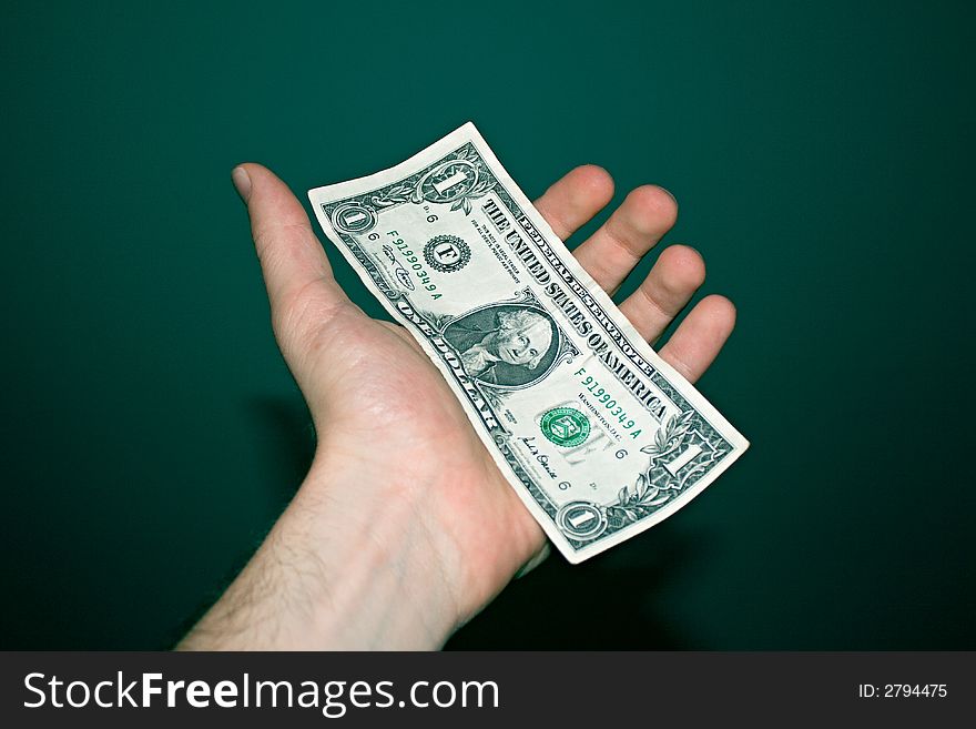 One paper dollar on a male's left palm. One paper dollar on a male's left palm