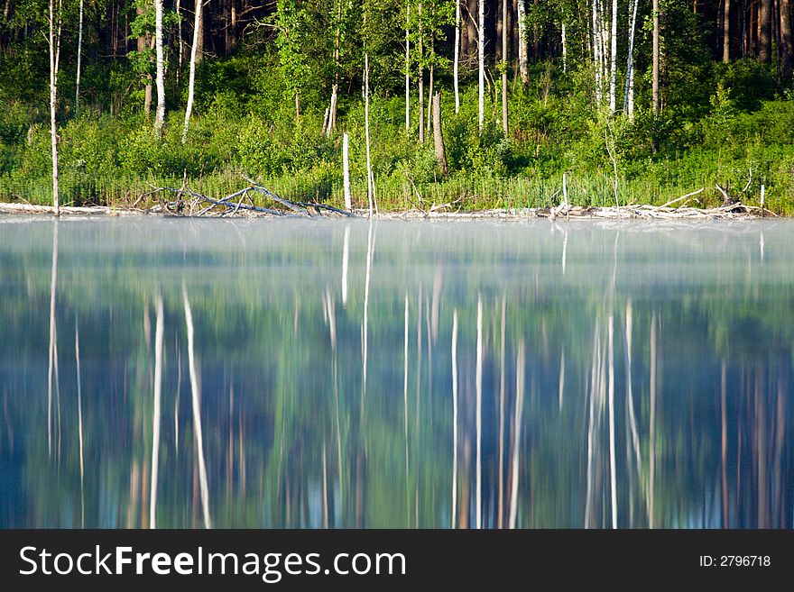 Lake with fog over it and trees at bank at sunrise. Lake with fog over it and trees at bank at sunrise