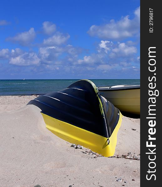 A Yellow on black rowboat on a beach in Tidsvideleje. A Yellow on black rowboat on a beach in Tidsvideleje