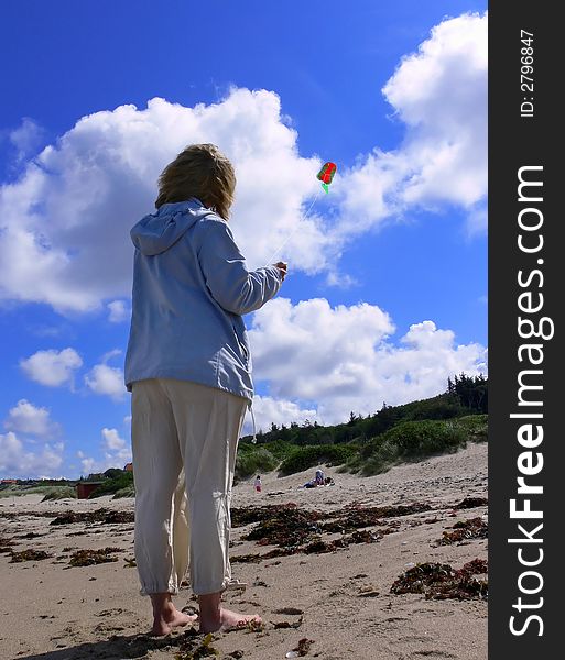 A girl flying a kite on the beach of Tidsvideleje Denmark