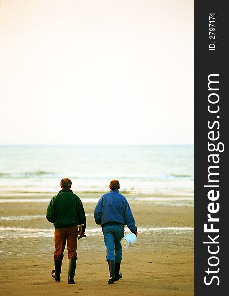 Two guys taking a walk on the beach in winter. Two guys taking a walk on the beach in winter