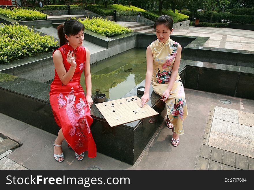 Asian young women play chess. Asian young women play chess