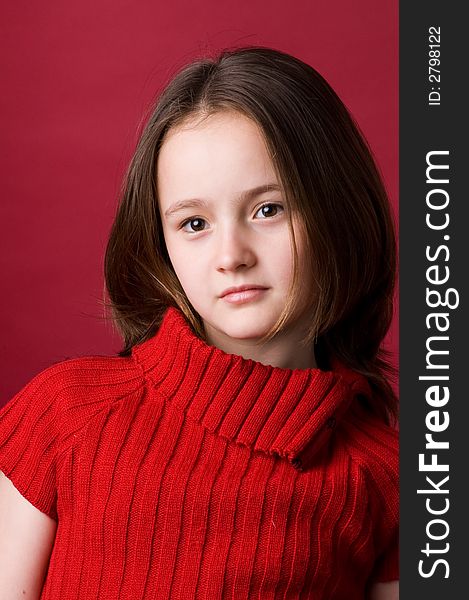 The girl of ten years in a red sweater in studio. The girl of ten years in a red sweater in studio