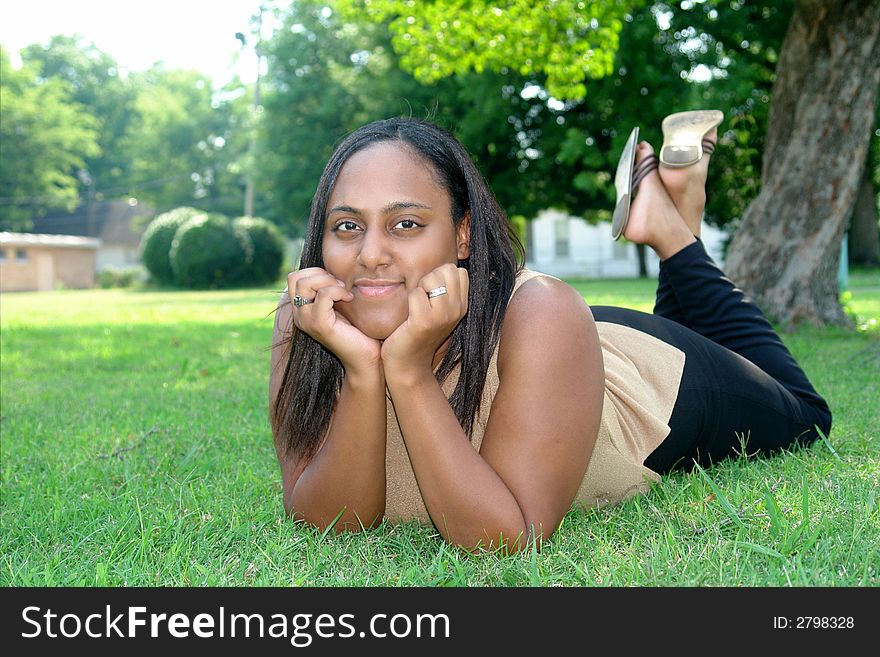 A picture of a beautiful woman in the grass in shade. A picture of a beautiful woman in the grass in shade