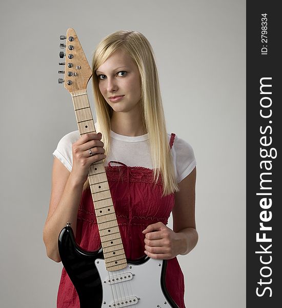 Pretty blonde teen girl holding electric guitar. Pretty blonde teen girl holding electric guitar