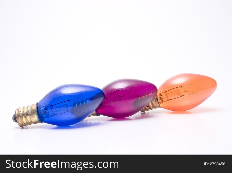 Three colored holiday light bulbs in a row. Isolated on white. Three colored holiday light bulbs in a row. Isolated on white.