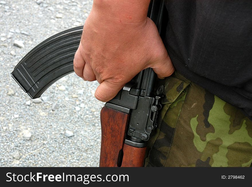 A detail of  a soldier´s hand holding  a machine rifle