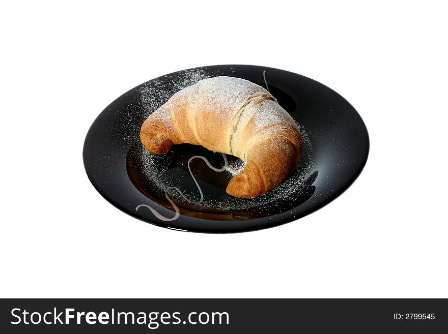 Croissant with sugar on the black plate