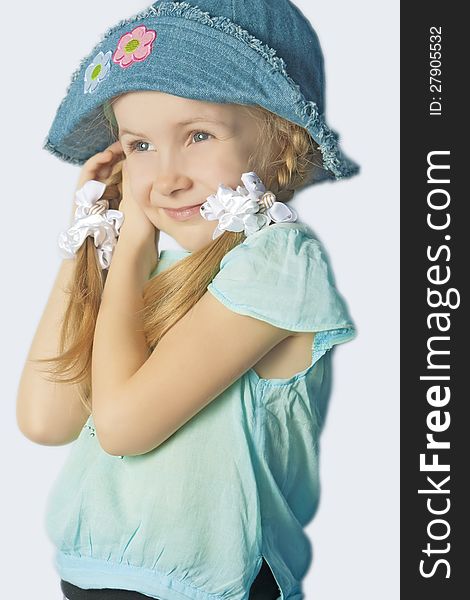 Portrait of a cute little girl in hat smiling standing with lifted hands