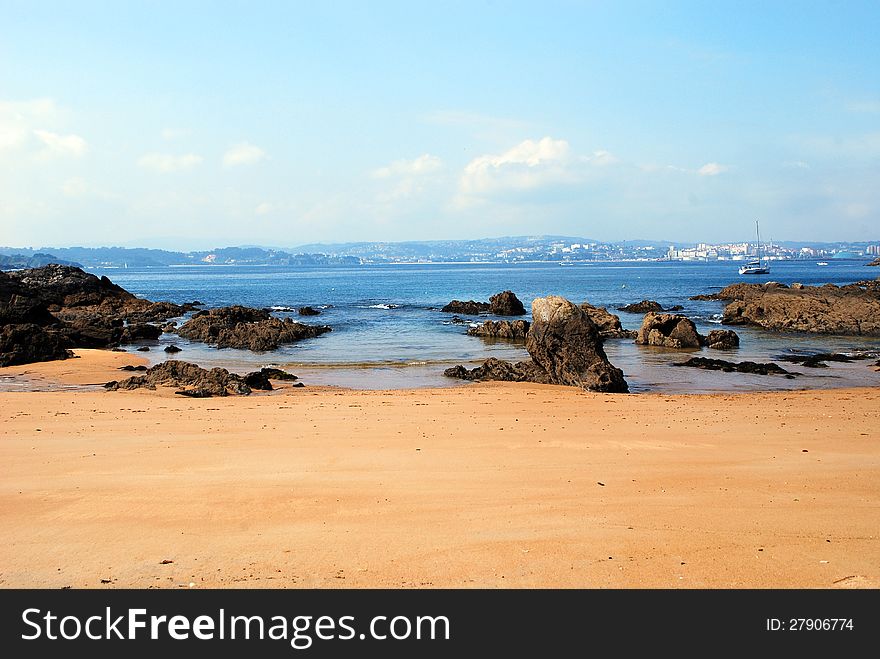 Rocky beach in the North of Spain in Corunia with city view in the background. Rocky beach in the North of Spain in Corunia with city view in the background.