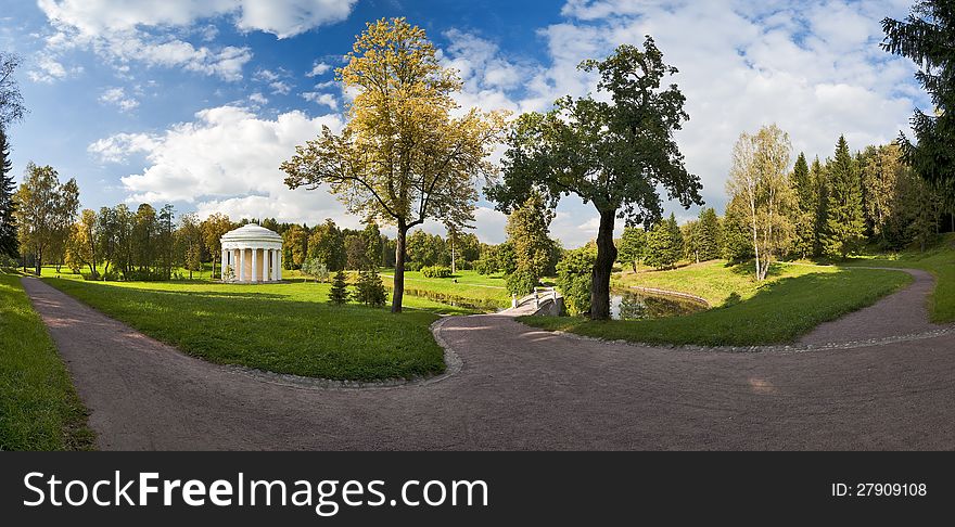 Panorama in the autumn park with classical bridge and rotunda