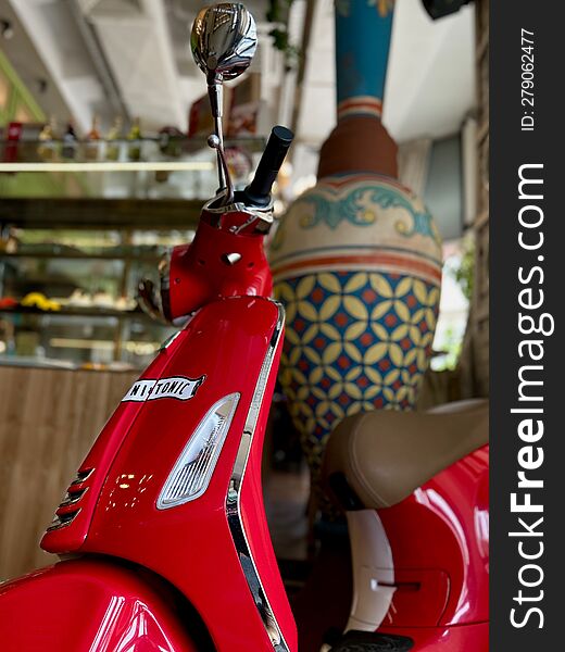 Shiny red moped in the interior of the room