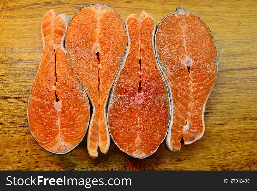 Four fish stakes on a wooden table. Close up. Four fish stakes on a wooden table. Close up