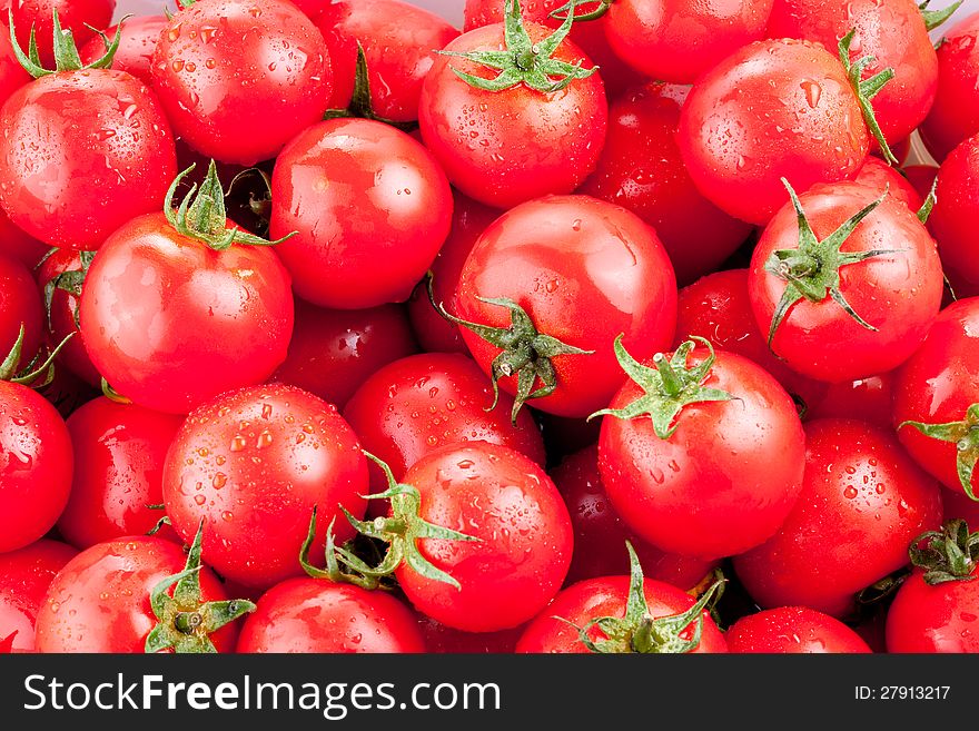 Multitude of ripe tomatoes. Red background.