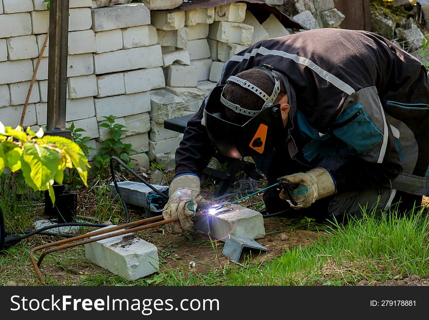 man doing welding while building his house