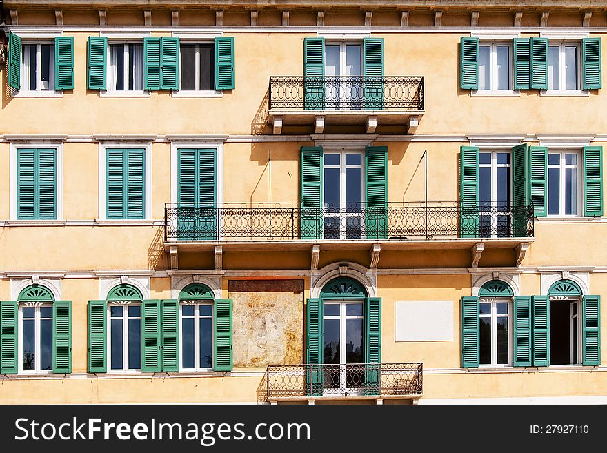 Terraces and green shutters of an old orange building in Verona, Italy. Terraces and green shutters of an old orange building in Verona, Italy