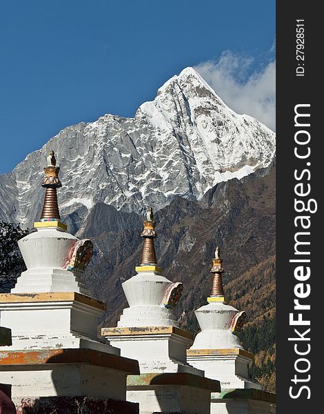 A row of Tibetan stupas at the foot of snow mountain