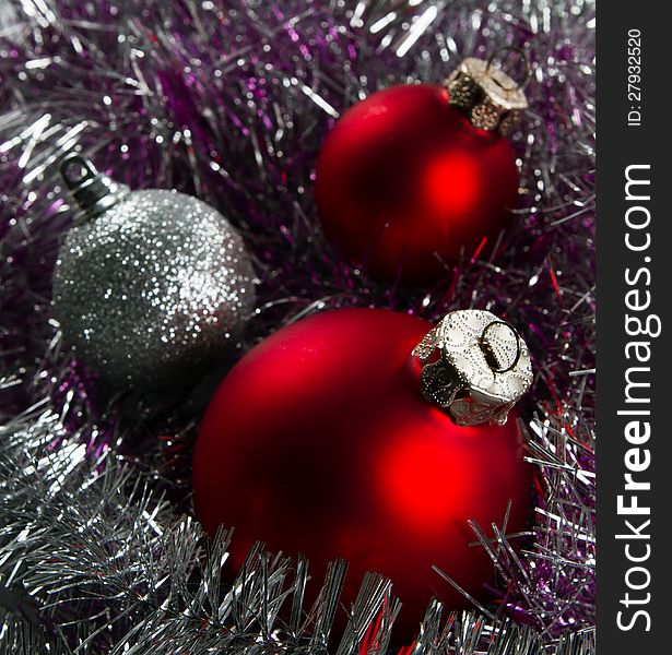 Red and silver Christmas baubles with green copy space