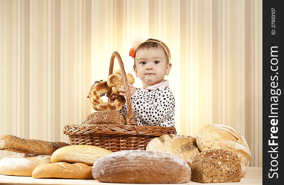 Baby girl choosing bread from basket. Baby girl choosing bread from basket