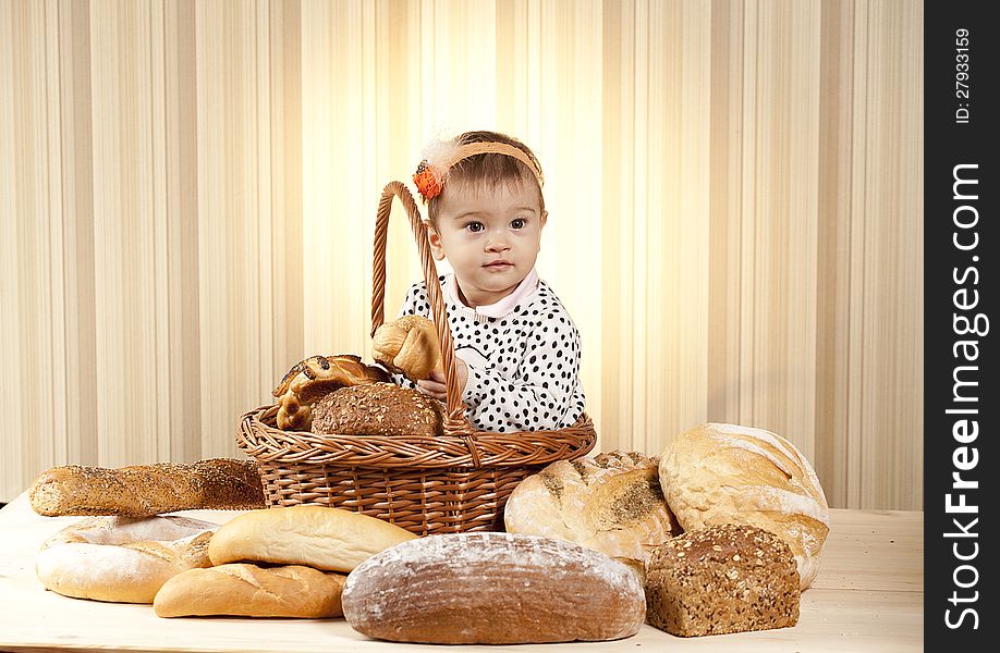 White infant eating bread from basket. White infant eating bread from basket