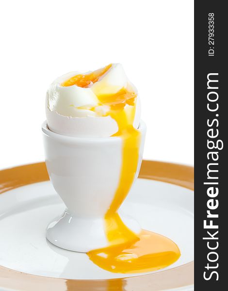 Soft-cooked egg in cup with yolk running out