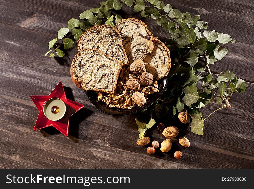 Green plant near candle burning and food decorating christmas table. Green plant near candle burning and food decorating christmas table