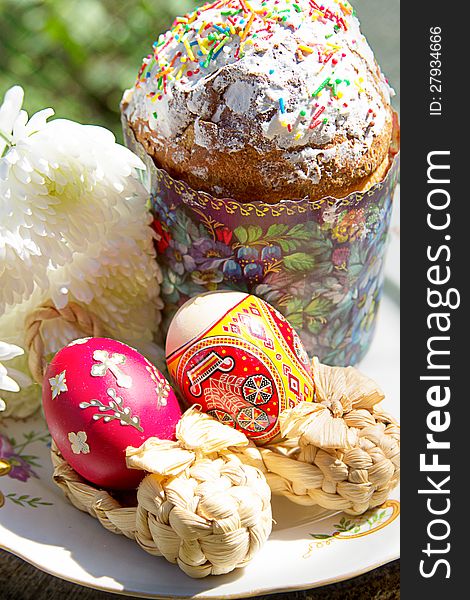 Easter cake with colorful eggs and flowers on plate