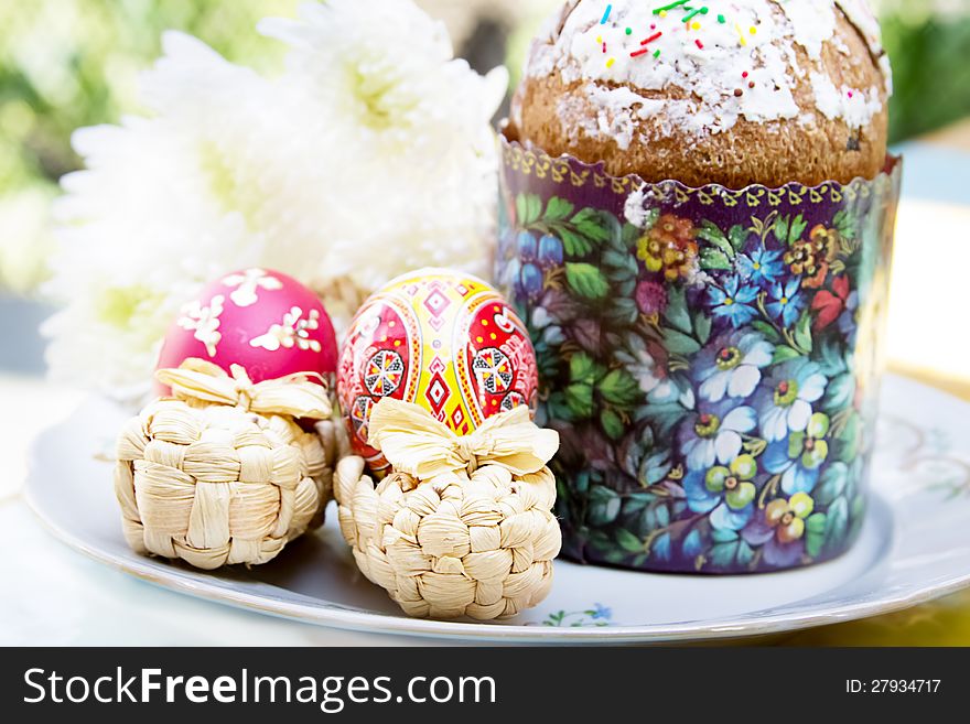 Easter cake with colorful eggs and flowers on plate