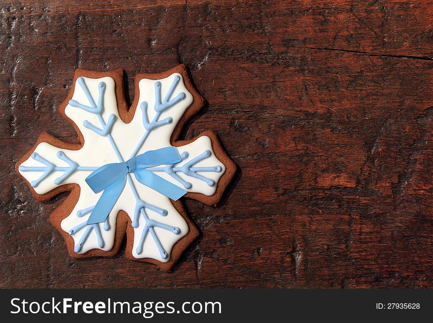 Christmas gingerbread snowflake cookie on a vintage wooden background. Christmas gingerbread snowflake cookie on a vintage wooden background.