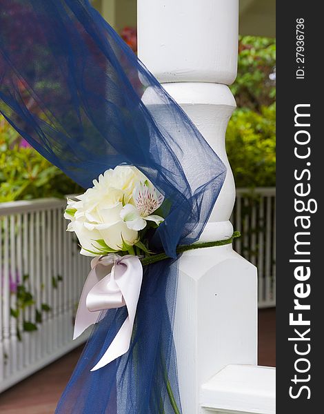 Wedding decor ribbon in blue on the post of a gazebo at an outdoor venue. Wedding decor ribbon in blue on the post of a gazebo at an outdoor venue.