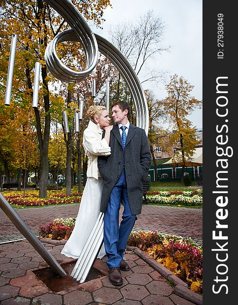 Bride And Groom About Iron Figure On Autumn