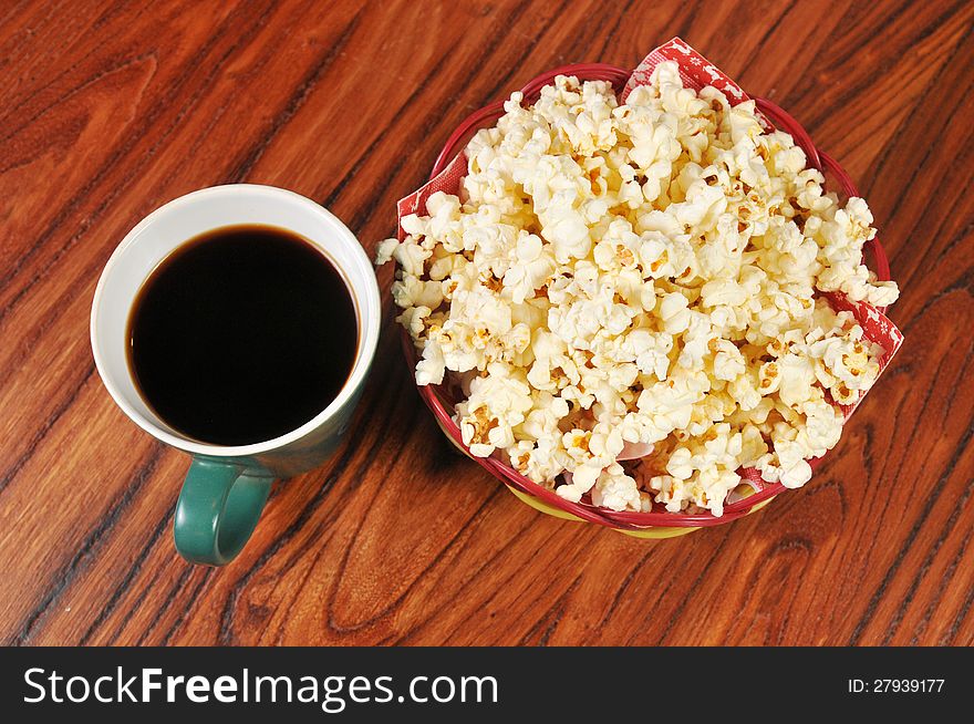 A bag of popcorn and a cup of coffee on the table. A bag of popcorn and a cup of coffee on the table