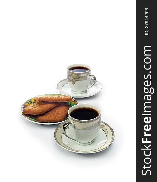 Two white cups of black coffee and cookies on a saucer on a white background