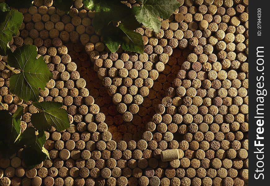 The letter V and the background of wine corks with grape leaves