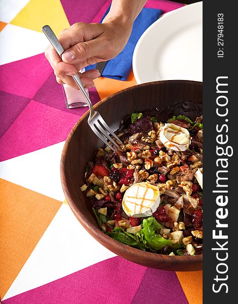 Big salad in wood bowl on colorful tablecloth. Big salad in wood bowl on colorful tablecloth